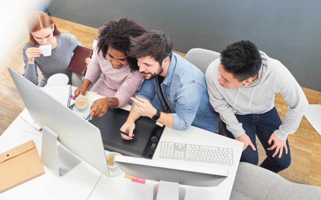 Personnes autour d'un bureau et ordinateur